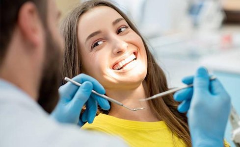 Woman smiling at dentist during dental treatment using Calaject local anesthesia